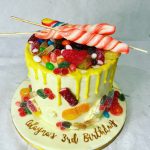 Children's birthday cake loaded with sweets and lollipops